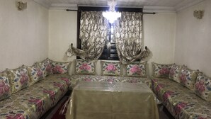 Una habitación con un conjunto de sofás, una mesa y una araña.