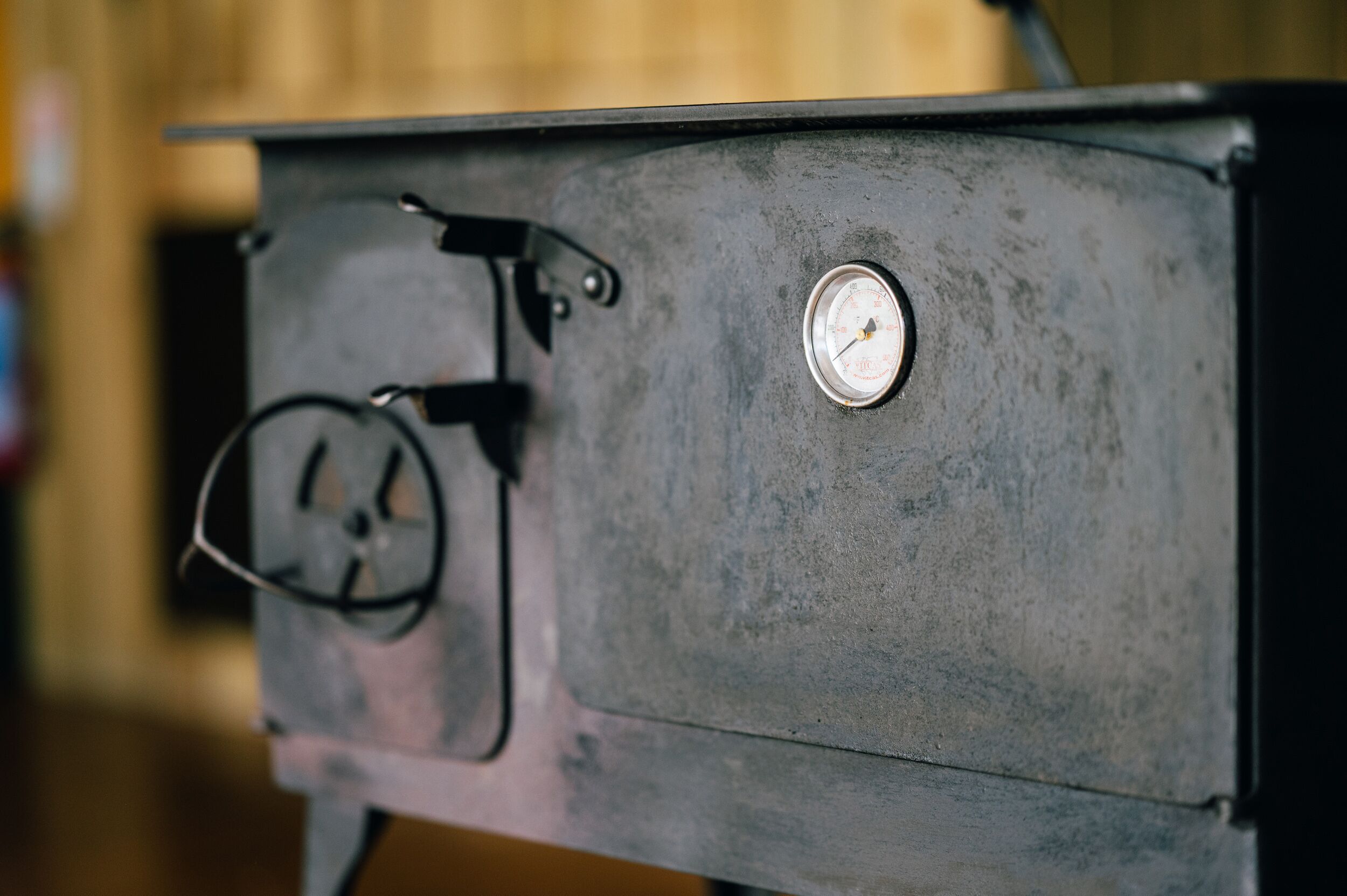 A close-up of a vintage stove with a pressure gauge and a control knob.