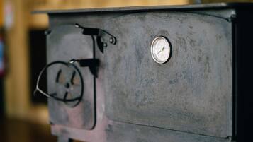 A close-up of a vintage stove with a pressure gauge and a control knob.