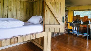 A wooden cabin with a bunk bed and a kitchenette.