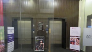 Interior de ascensor con un cartel que indica 'Servicio de lavandería abierto'.