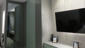Un baño moderno con un espejo grande, un inodoro y un lavabo.