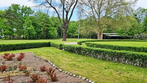A park with manicured lawns, hedges, and a playground. - Karczma Ostoya (Trzebownisko)