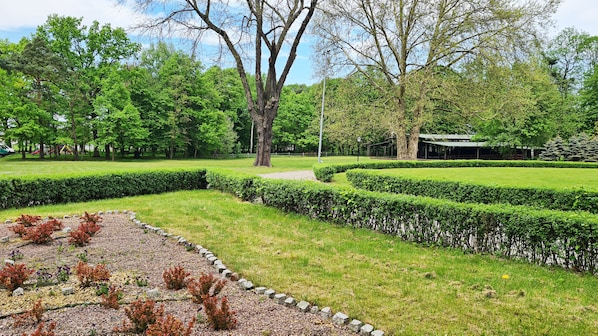 A park with manicured lawns, hedges, and a playground.