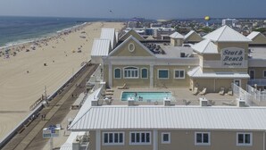 Un hôtel situé en bord de mer, doté d’une piscine, d’un accès à la plage et d’un panneau indiquant « South Beach Boardwalk ».