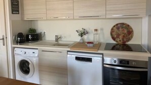 Eine moderne Küche mit Waschmaschine, Geschirrspüler und Backofen.
