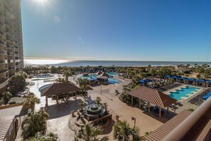 Et resort med flere swimmingpools, en central springvand og udsigt til stranden.