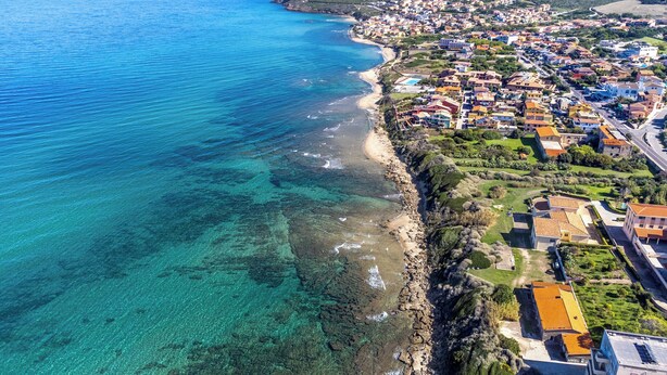 An aerial view of a coastal town with clear blue waters, a sandy beach, and densely packed buildings. - Holiday apartment close to the beach (Santa Teresa di Gallura)
