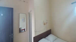 A room with a bed, a door, a mirror, and an air conditioning unit. - OYO 93668 Buah Batu Guest House (Bandung)