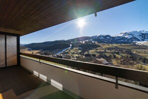 En balkon med udsigt over et bjergrigt landskab og en klar himmel.