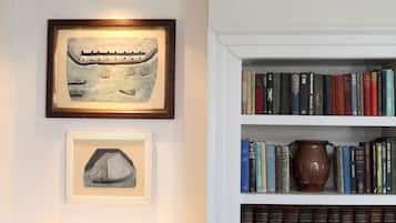 Una estantería con libros y una jarra de cerámica.