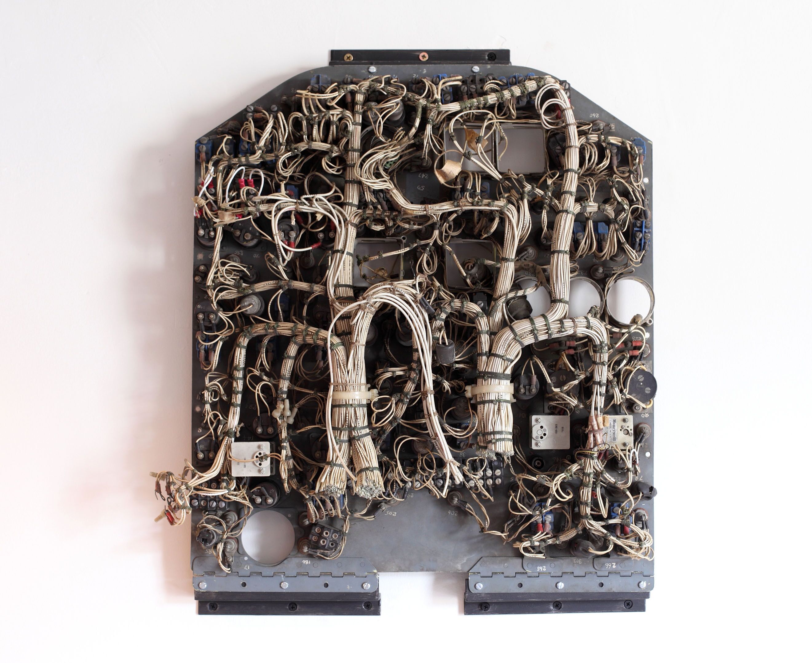 A complex electronic device with numerous wires and components, mounted on a black platform with a metal frame.