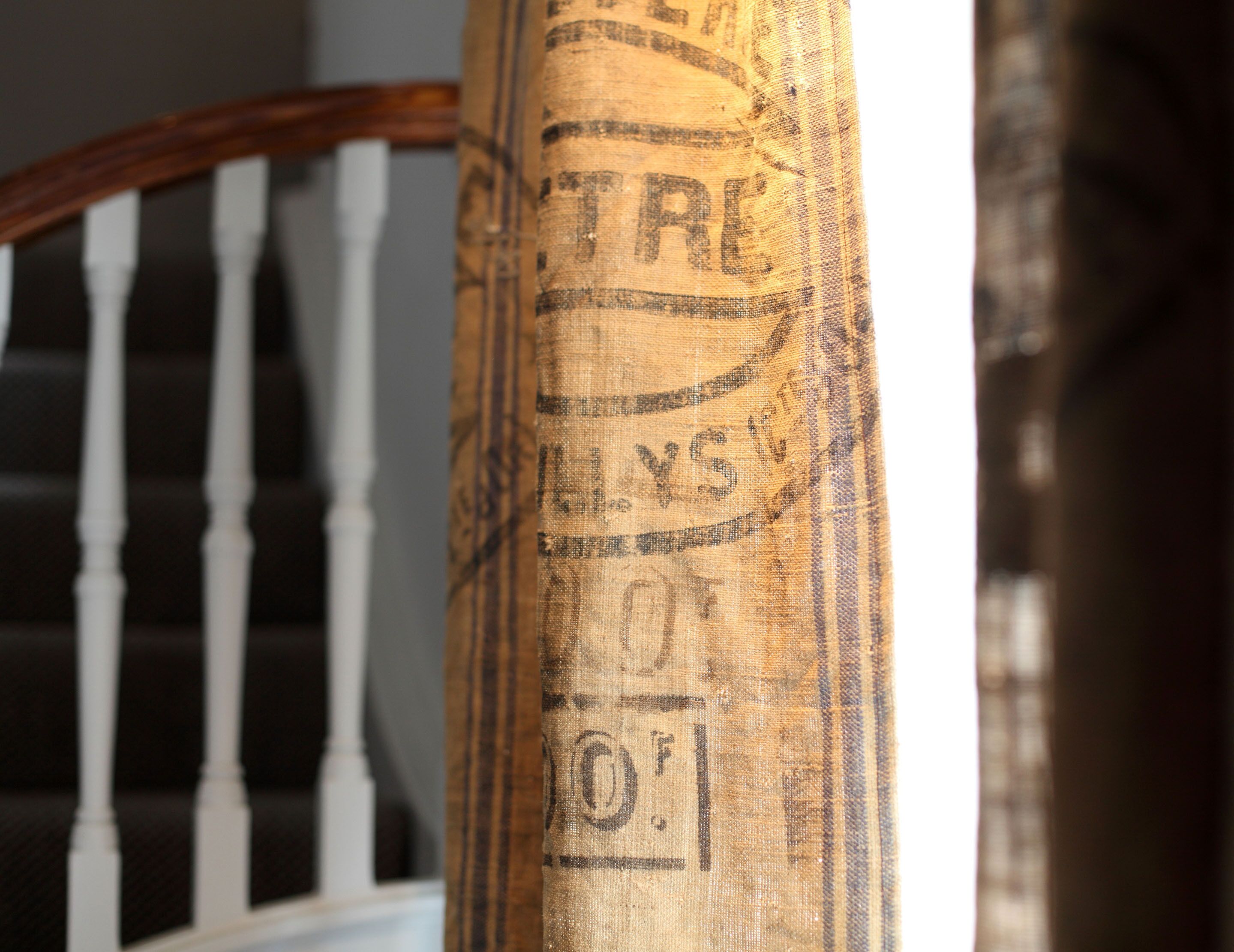 A close-up of a textured fabric with printed text, likely part of a staircase railing.