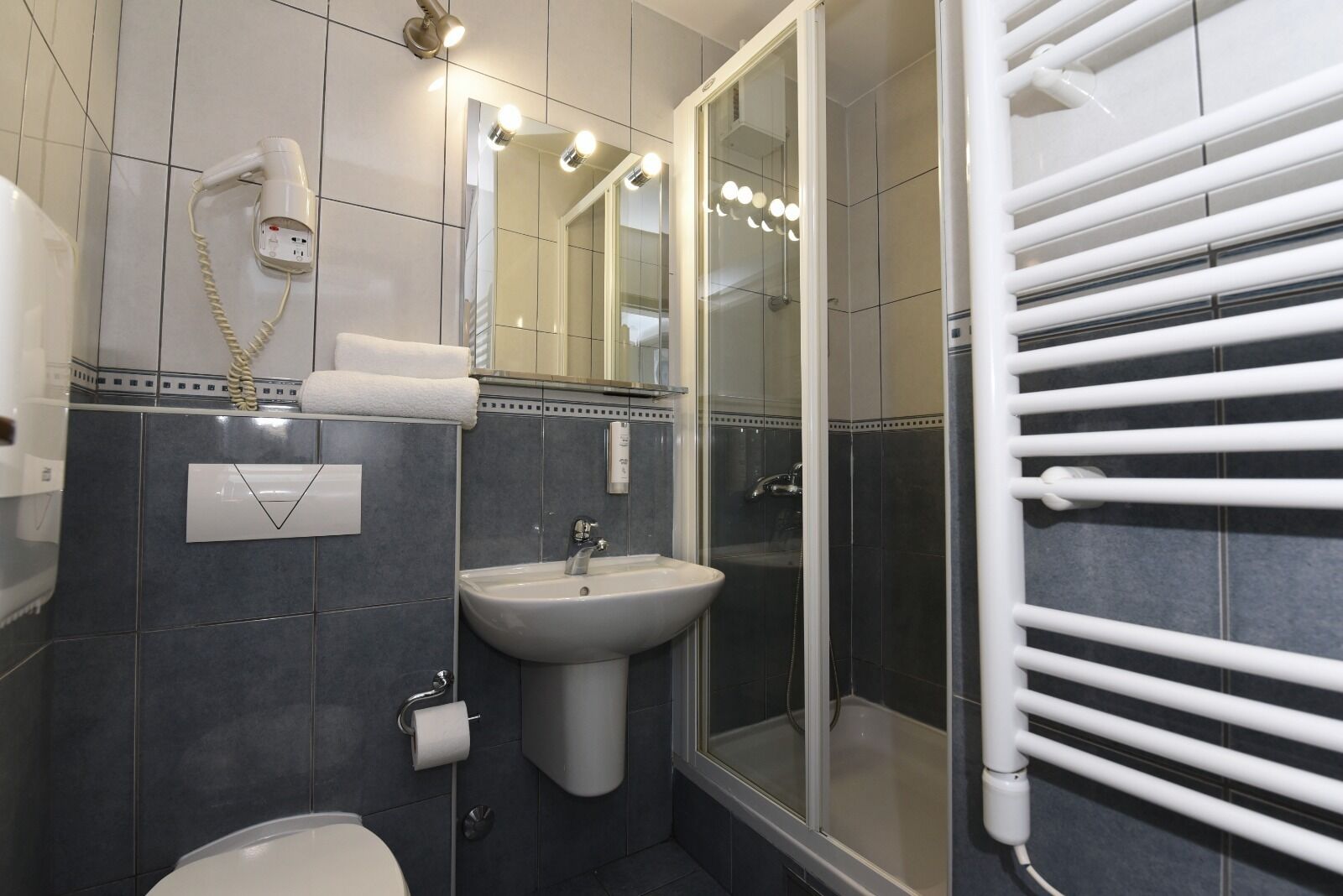 A bathroom with a sink, mirror, and towel rack.