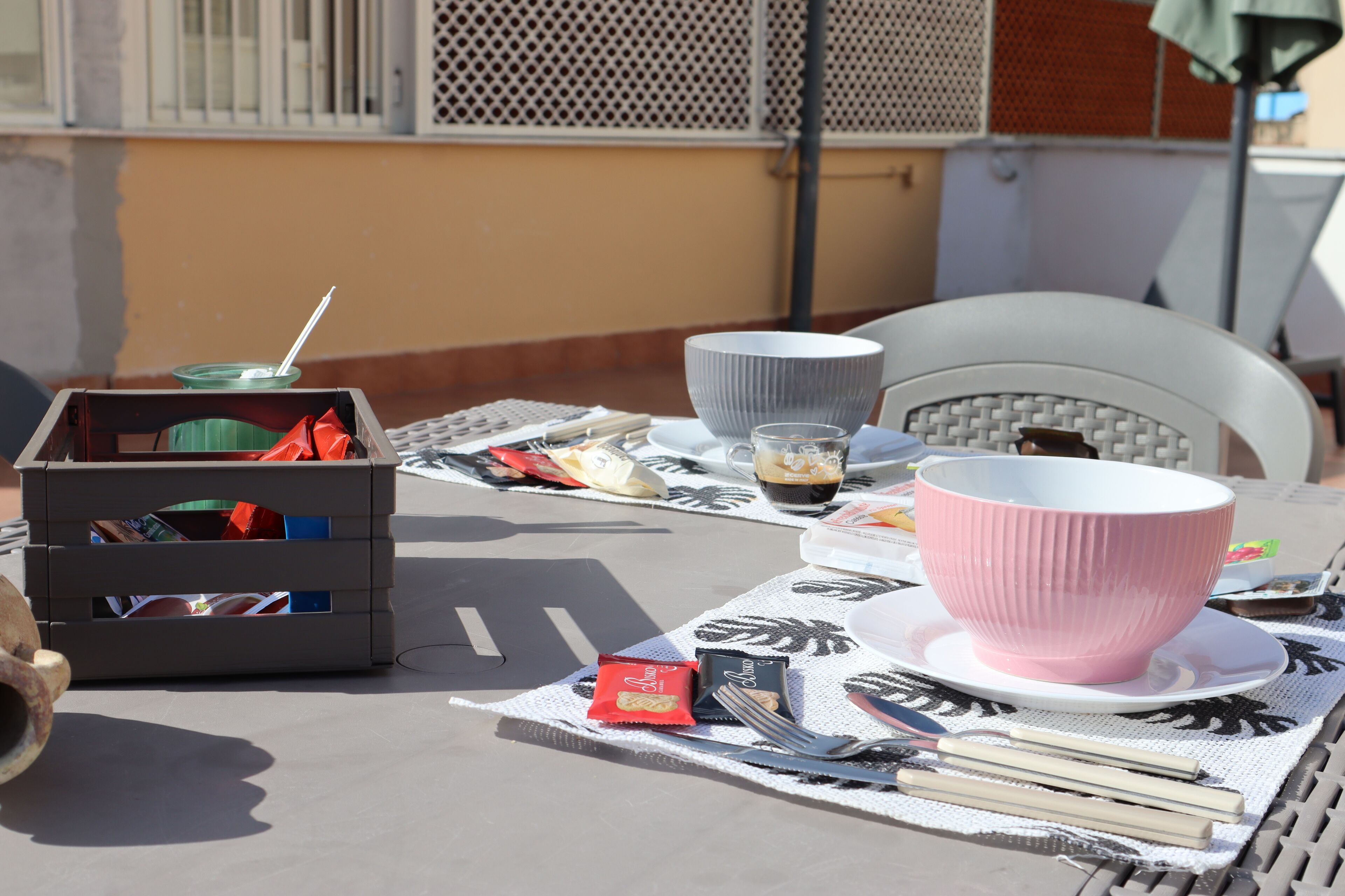 Una mesa servida con diferentes platos, un bol, una taza y una pequeña caja.