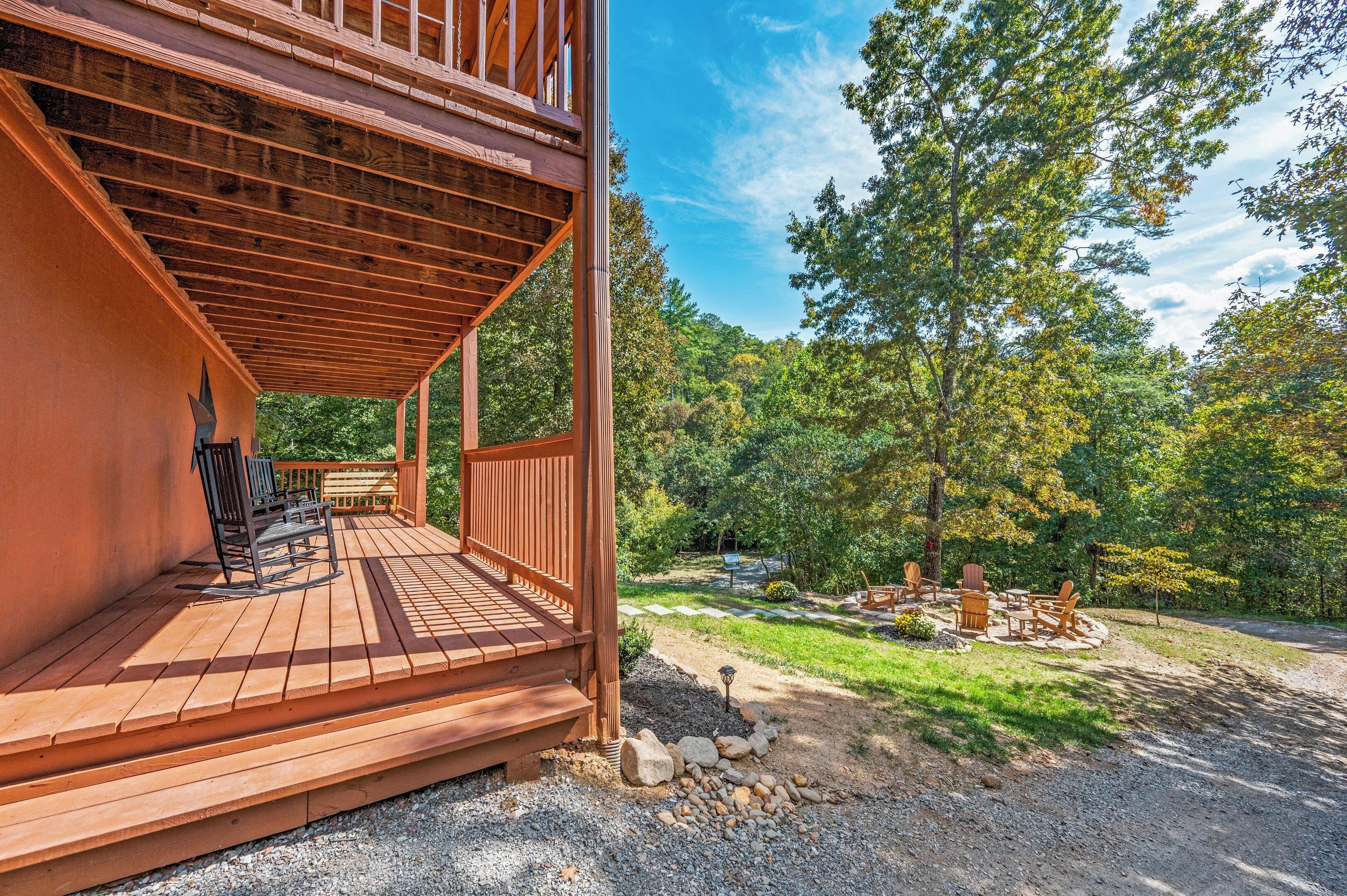 Une terrasse en bois avec des sièges extérieurs, entourée d’un paysage boisé.