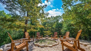 A circular seating area with Adirondack chairs around a fire pit, surrounded by a gravel path and trees. - Hot Tub ★ Pool Table ★ Firepit ★Very Private (Townsend)