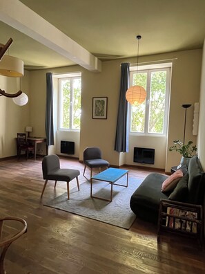 A living room with a fireplace, two chairs, a sofa, and a coffee table. - Au Bord de la Rive (Lormont)