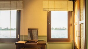 A room with a desk, chair, and a view of a body of water through a window. - HMC Zahra Dahabyia (Armant)