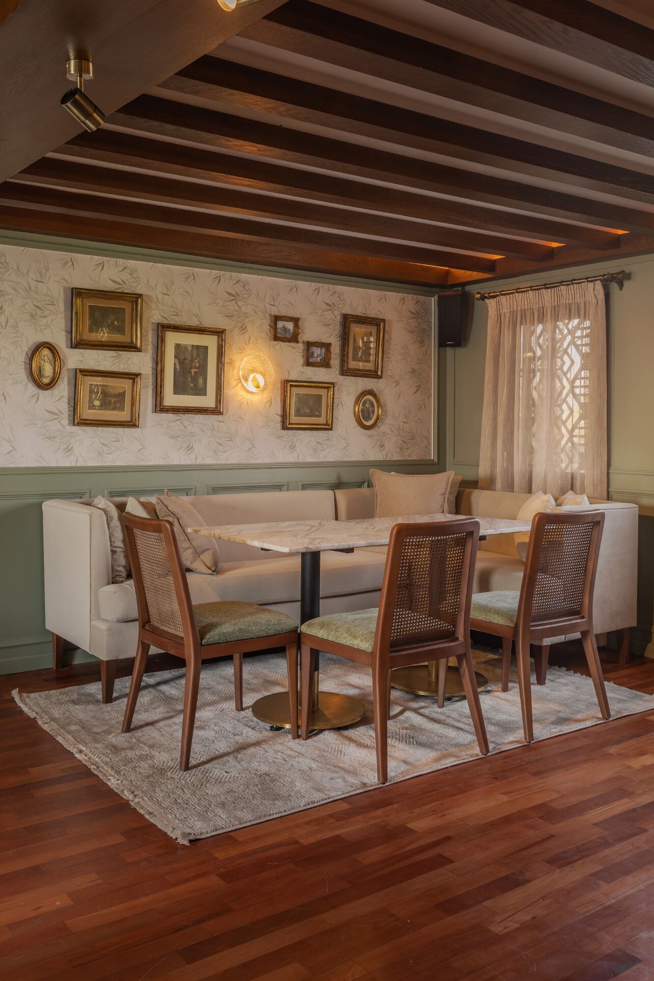 Een gezellig eetgedeelte met een houten plafond, een bank en een tafel met stoelen.