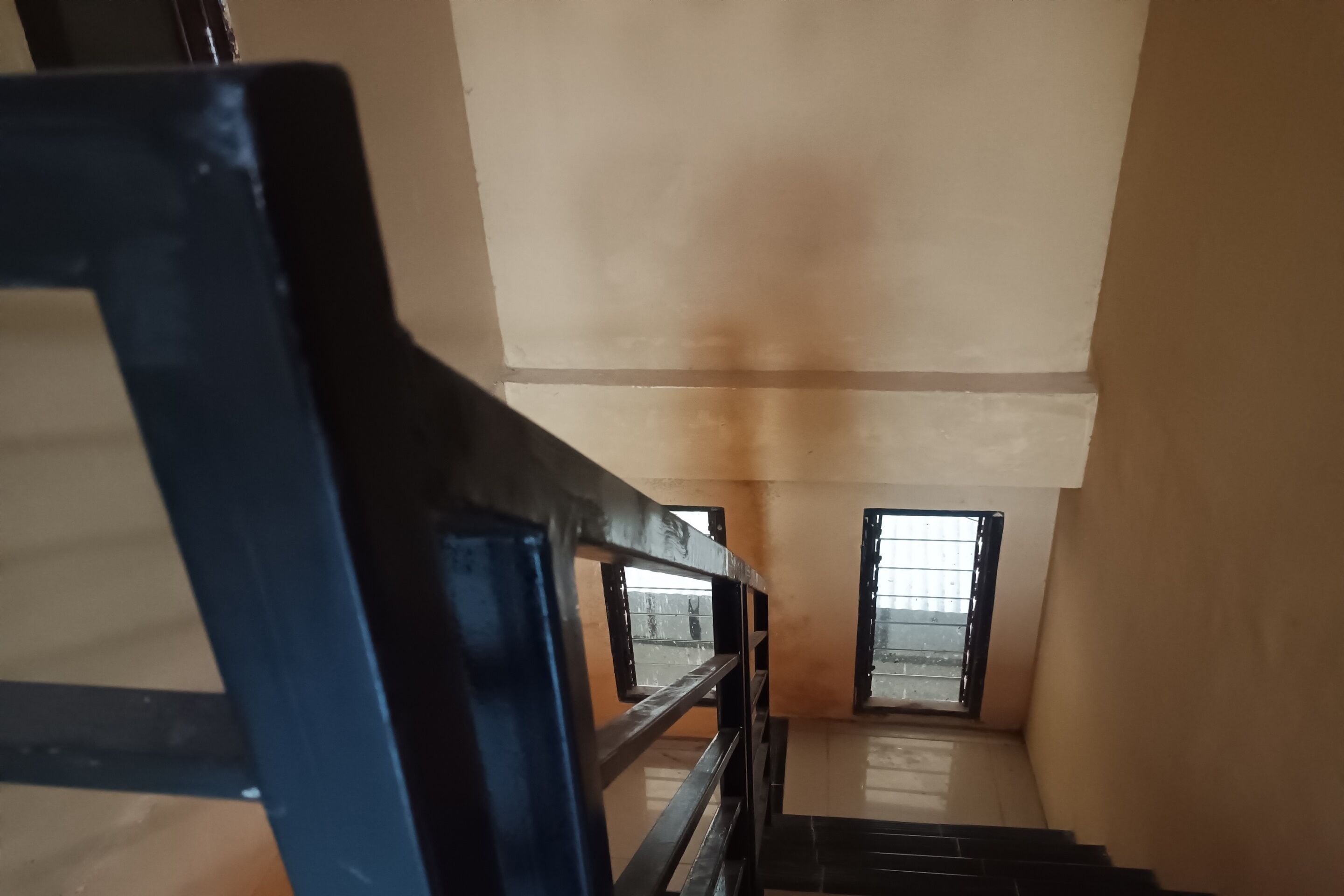 A staircase leading to a window with a metal railing.