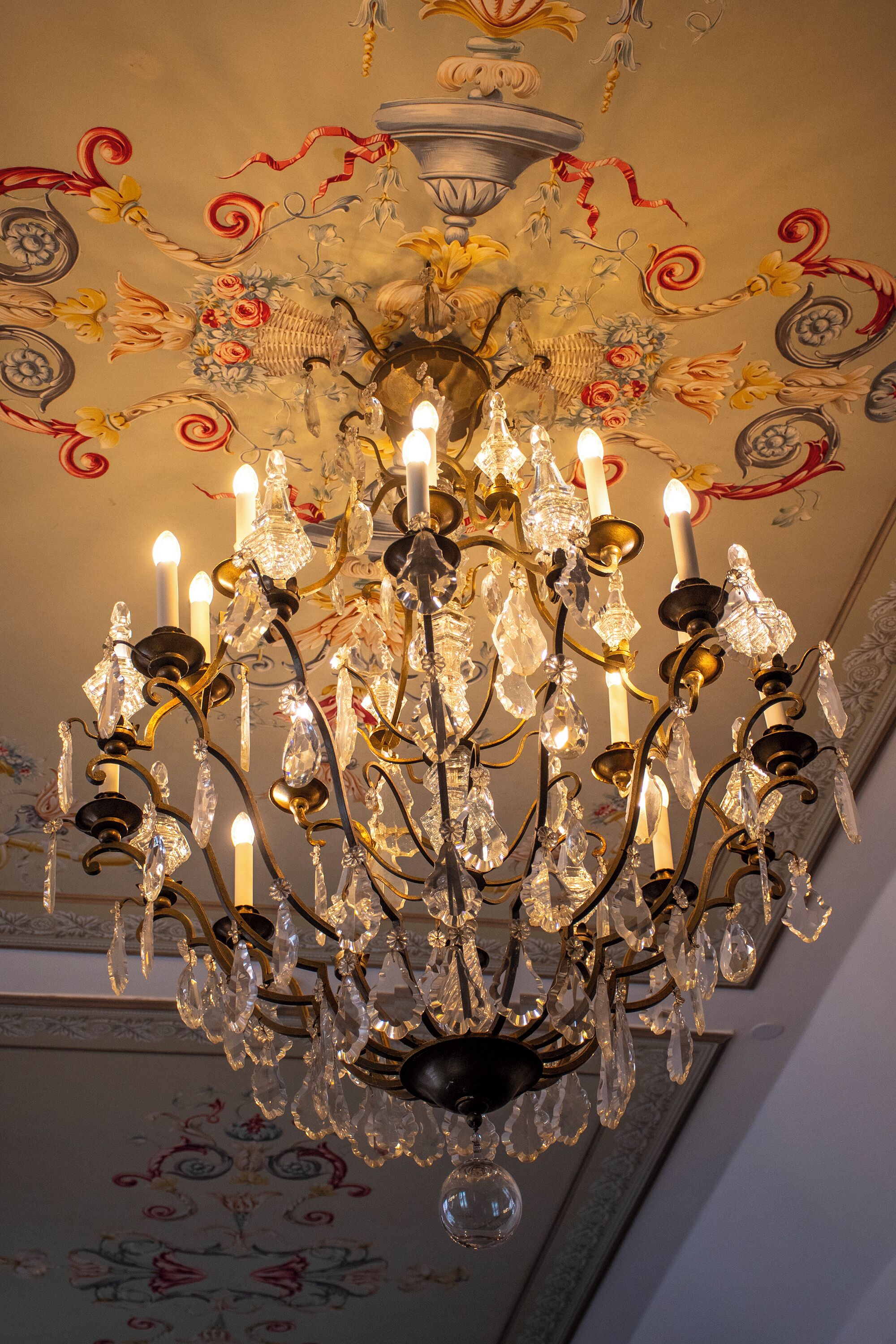 A chandelier with multiple candle-like lights and crystal decorations.