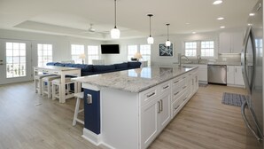 A modern kitchen with white cabinetry, a granite countertop, and stainless steel appliances.