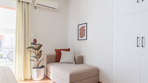 A bedroom with a bed, a potted plant, a framed picture, and a wardrobe. - Petite 1BR Apartment in Exarchia (Athens)