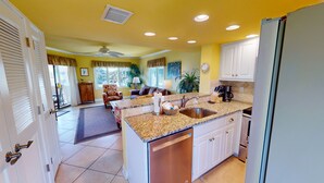 A kitchen with granite countertops, a dishwasher, and a sink. - Spectacular Penthouse Oasis with Mesmerizing Ocean Views (Isle of Palms)