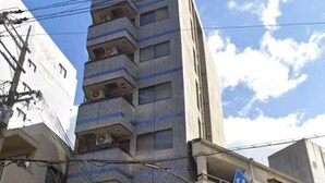 A multi-story building with a pedestrian crossing sign. - City Heights (Osaka)