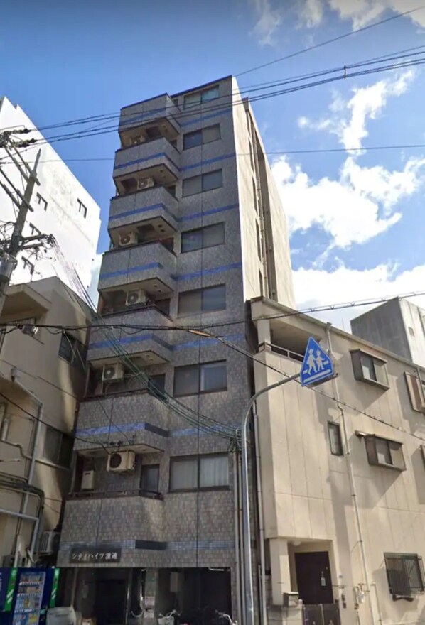 A multi-story building with a pedestrian crossing sign. - City Heights (Osaka)