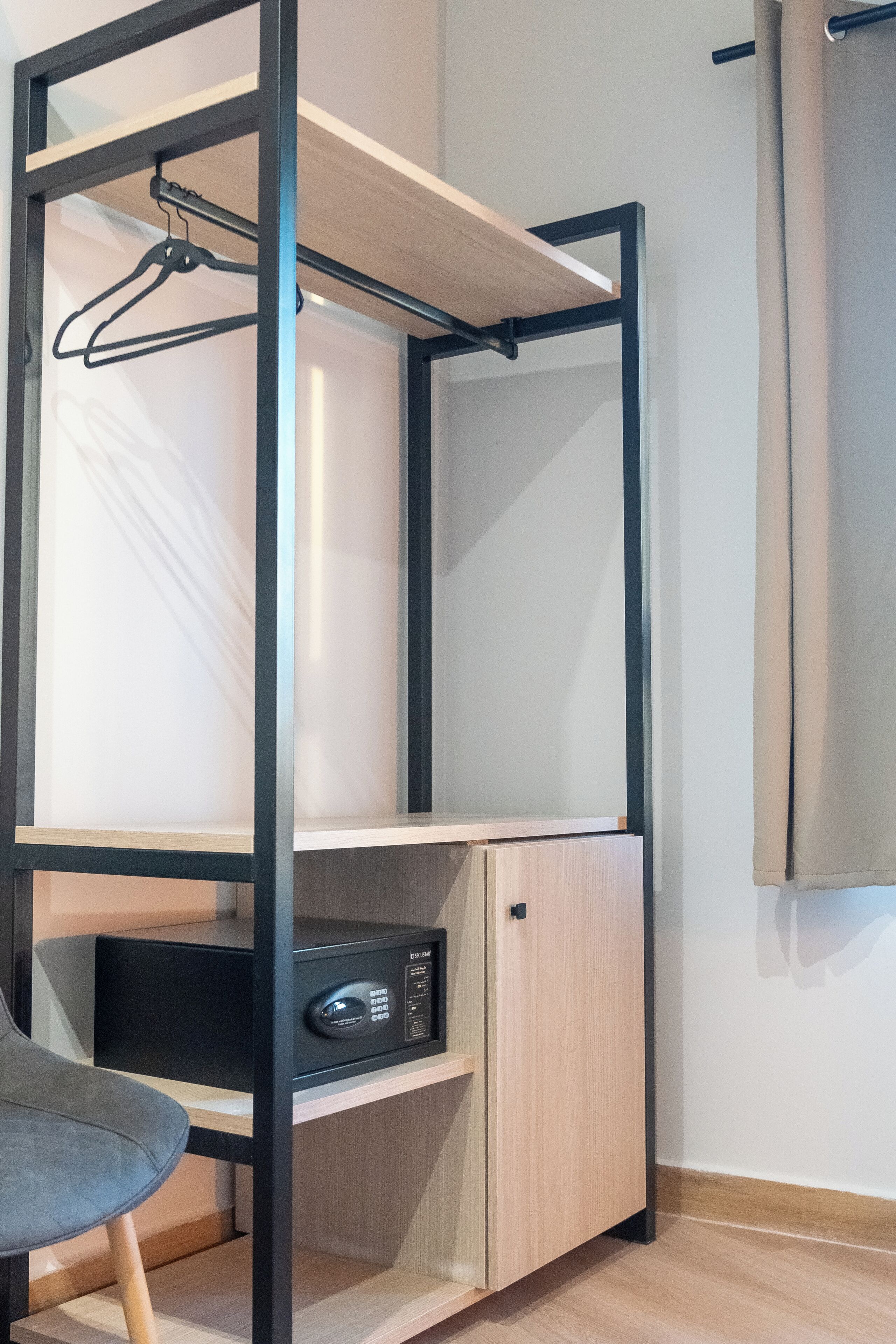 A bunk bed with a desk and a chair, a radio, and a curtain.