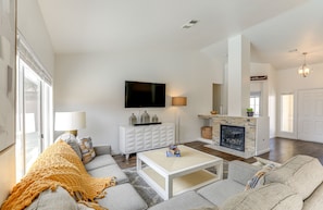 Una sala de estar moderna con sofá, mesa de centro, chimenea y televisor.