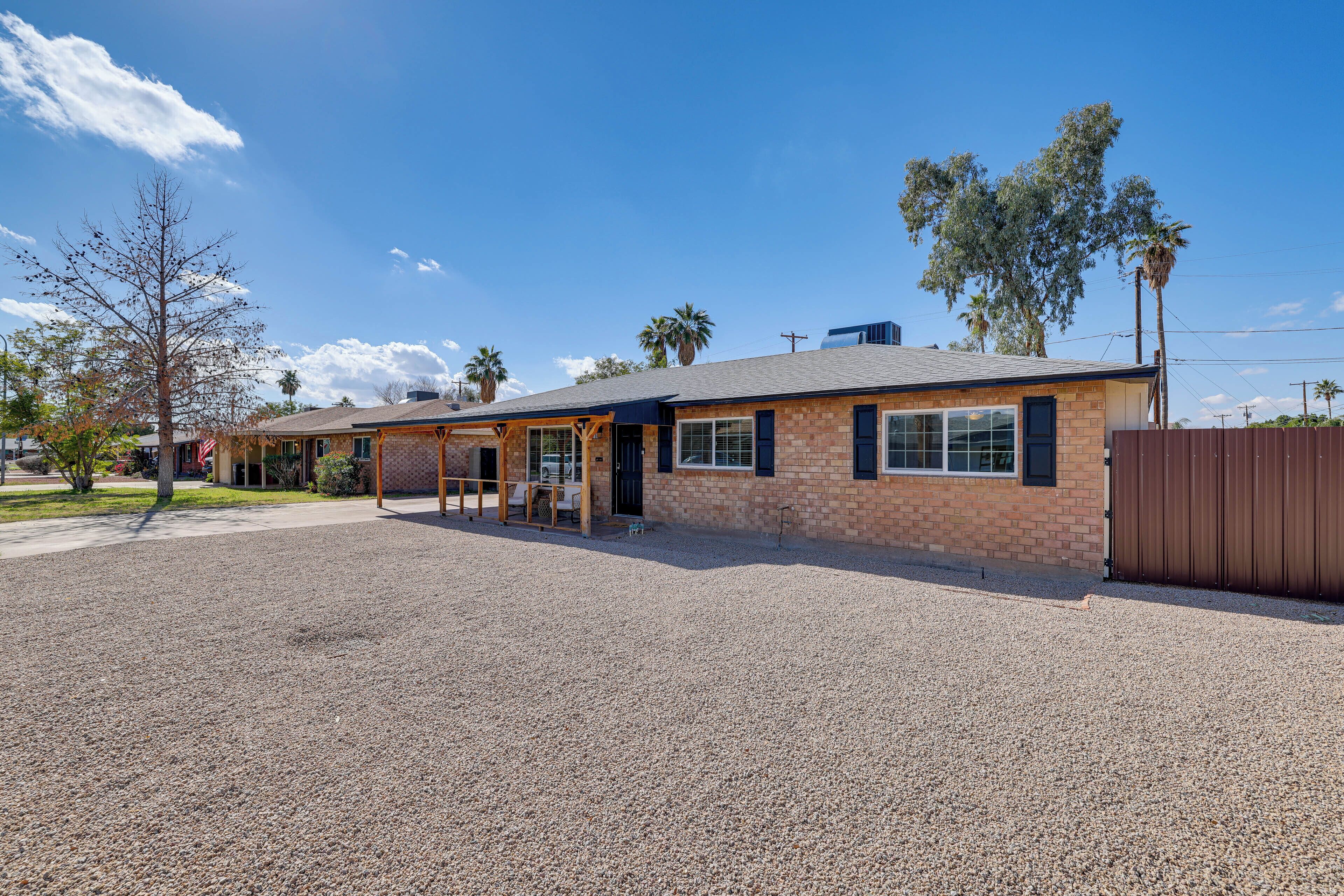 A single-story building with a brick facade, a covered porch, and a gravel driveway.