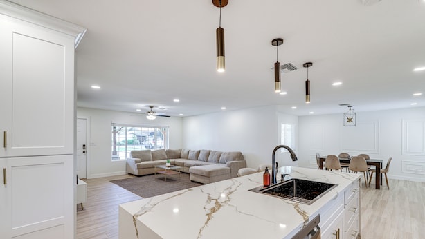 A modern kitchen with a marble island, white cabinetry, and pendant lighting. - 3 Mi to Old Town: Home w/ Game Room in Scottsdale! (Scottsdale)