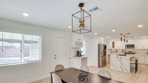 A modern kitchen with white cabinets, a marble island, and pendant lighting. - 3 Mi to Old Town: Home w/ Game Room in Scottsdale! (Scottsdale)