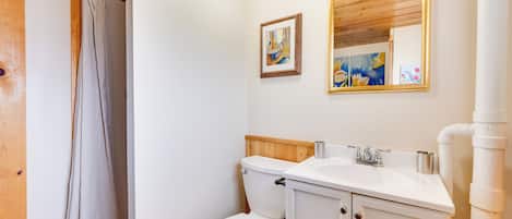 Ein Badezimmer mit Toilette, Waschbecken und Spiegel.