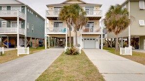 A row of two-story residential buildings with balconies, a central walkway, and a small lawn area.
