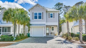 A two-story house with a garage, surrounded by palm trees and a paved driveway. - Stunning Santa Rosa Beach Home, 1/2 Mi to Ocean! (Santa Rosa Beach)