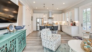 A spacious kitchen with white cabinets, a central island, and pendant lighting. - Stunning Santa Rosa Beach Home, 1/2 Mi to Ocean! (Santa Rosa Beach)