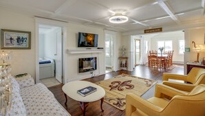 A spacious living room with a fireplace, comfortable seating, and a dining area.
