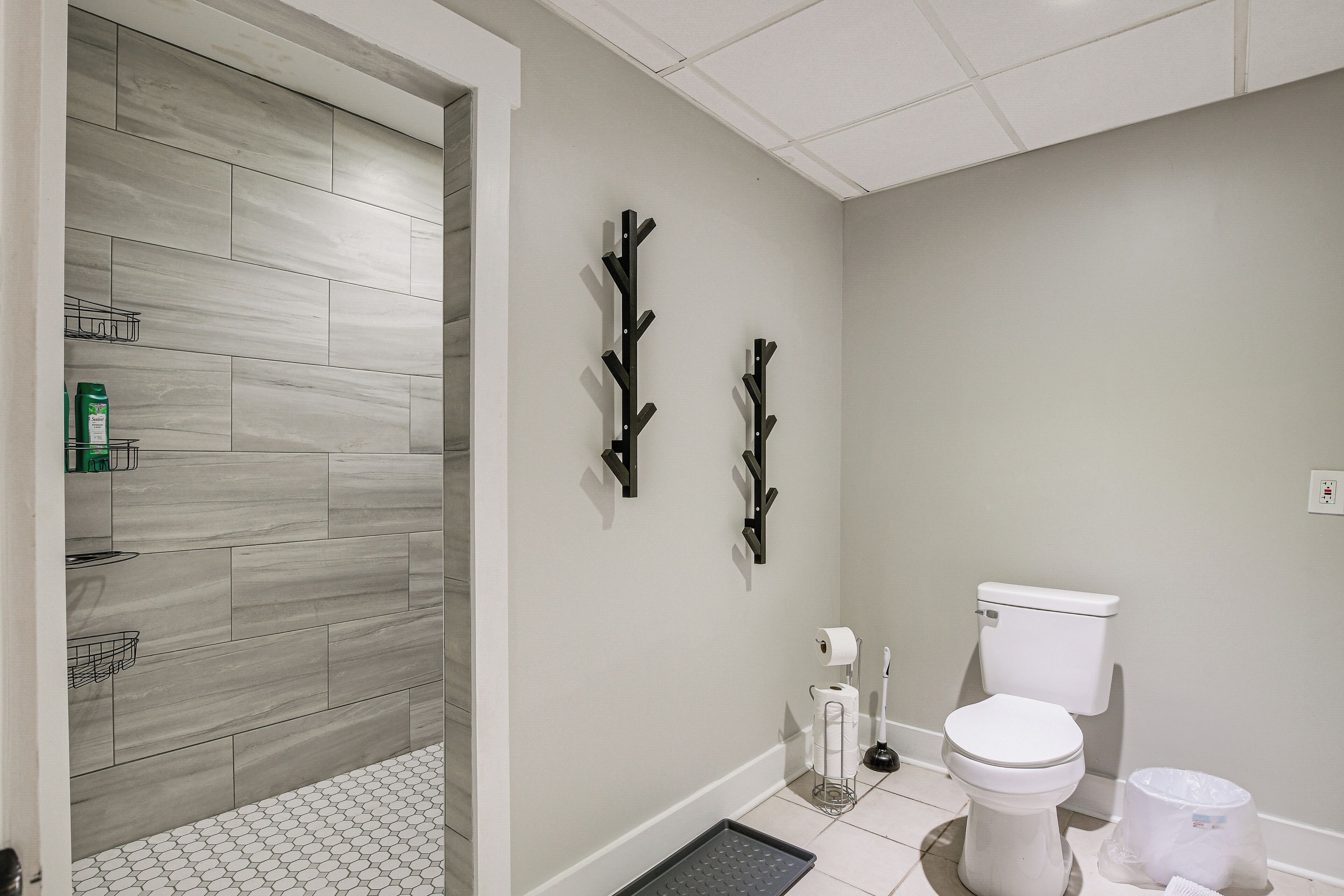 A bathroom with a toilet, a shower area, and a sink.