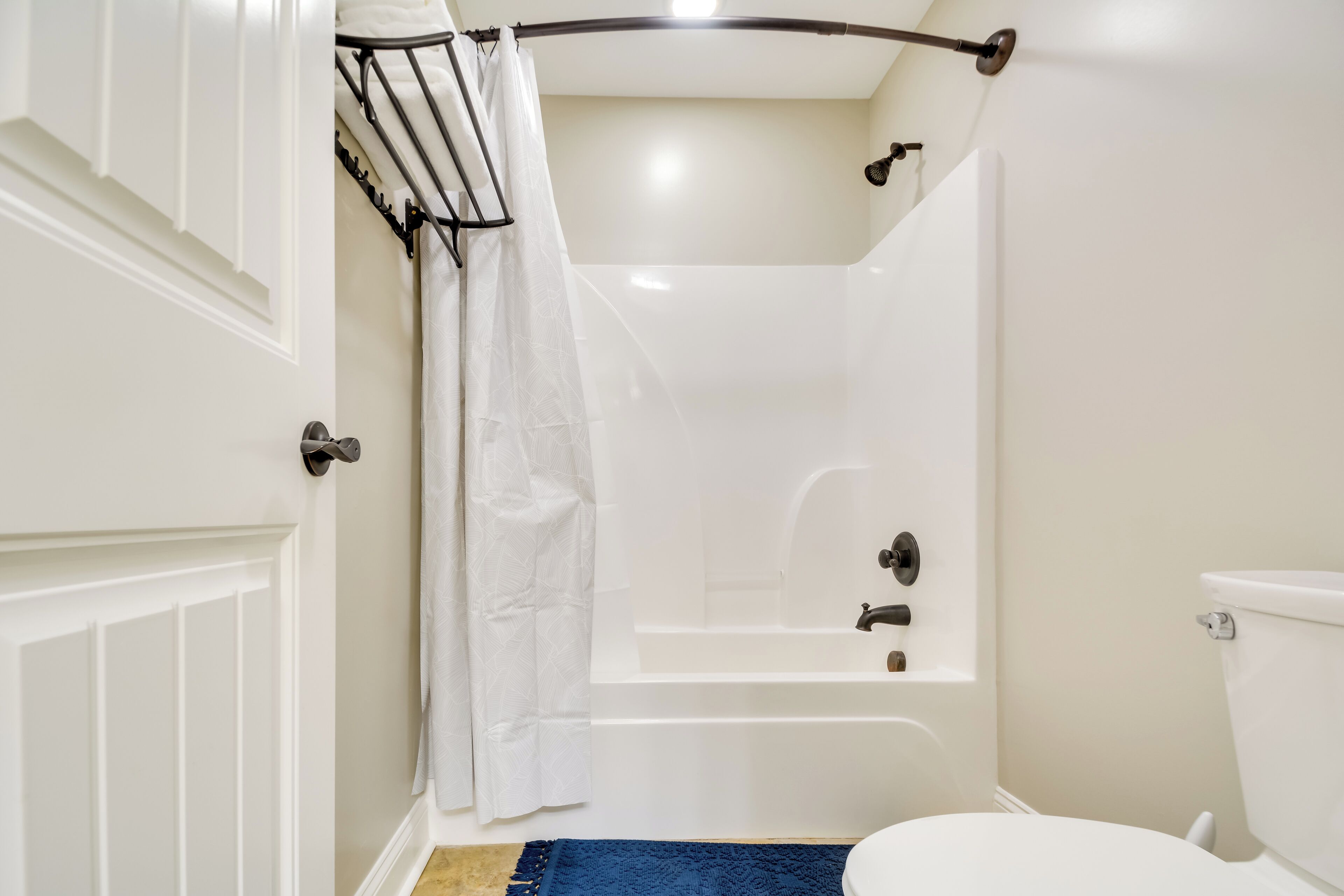 A bathroom with a bathtub, toilet, and a shower curtain.