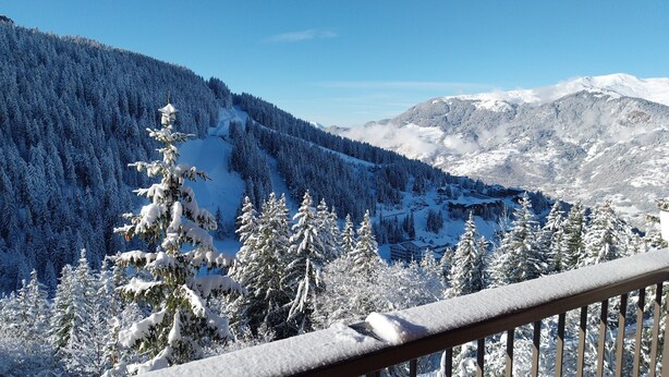 Paisaje montañoso cubierto de nieve con vistas a una zona turística.