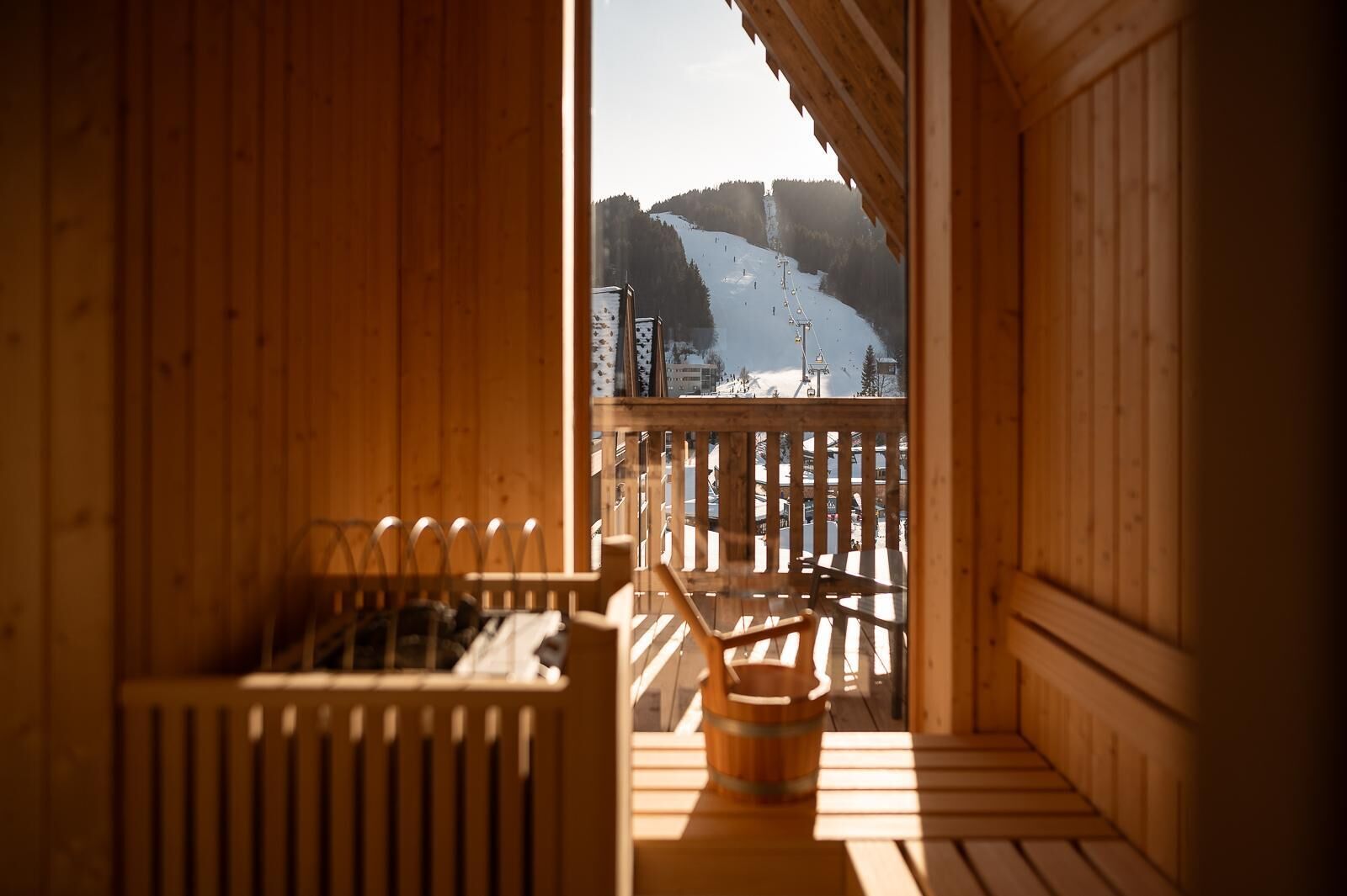 Une cabane en bois offrant une vue sur une pente de montagne enneigée.