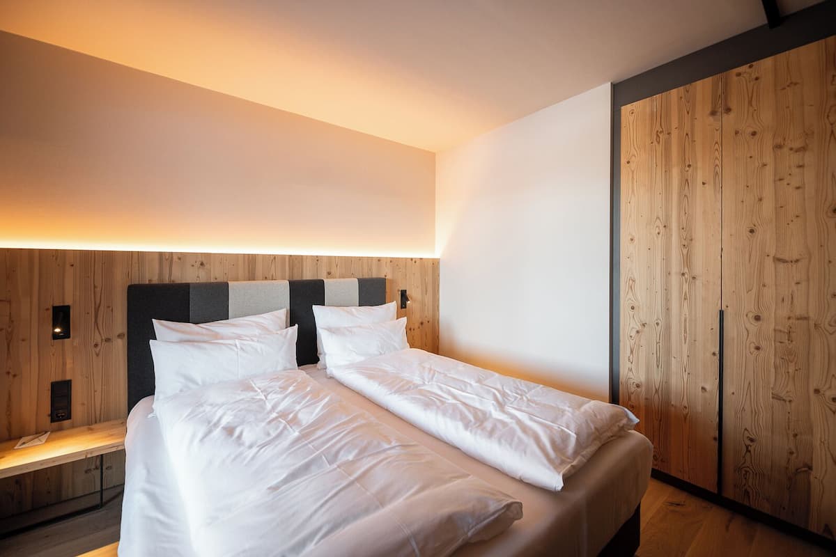 Ropa de cama hipoalergénica y caja de seguridad en la habitación