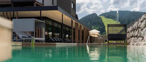 Una piscina techada, una piscina al aire libre de temporada, sombrillas