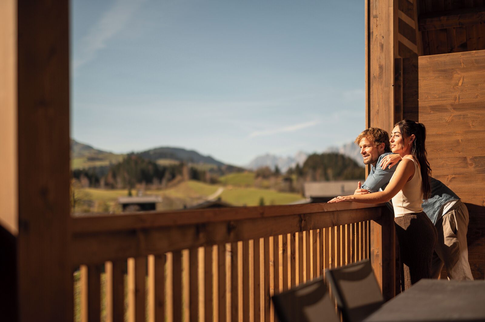 Un balcón de madera con vistas a un paisaje rural.