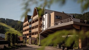 Een hotel met meerdere verdiepingen, met een modern design, voorzien van balkons en een bordje met de tekst 