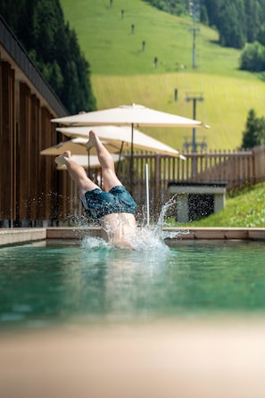 Una piscina cubierta, una piscina al aire libre de temporada, sombrillas